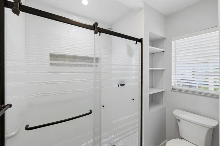 Another view of the primary bath shower and toilet area along with window for light and bright!
