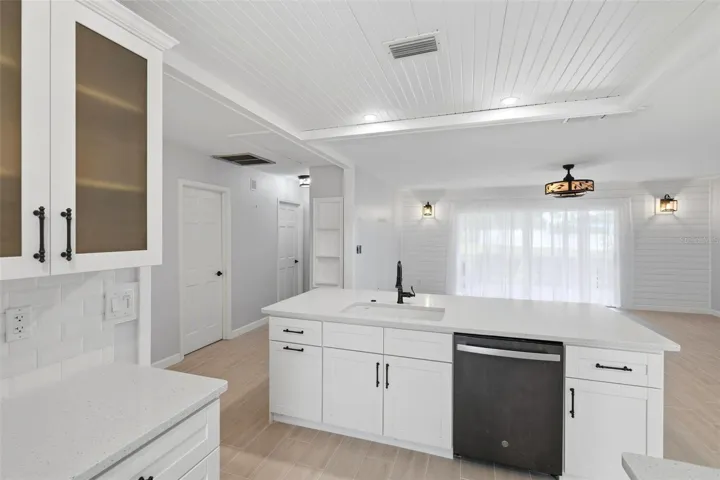 The opposite side of breakfast bar shows the sink, dishwasher and extra storage cabinetry.
