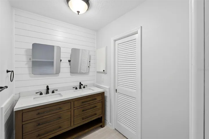 Primary ensuite bathroom with double sinks and mirrors.