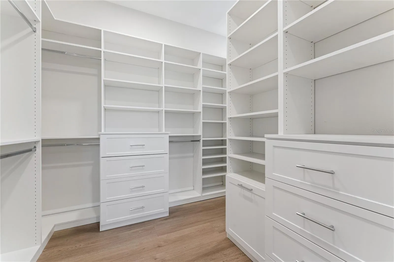Built-in shelves, drawers, and hanging rods provide organized closet storage.