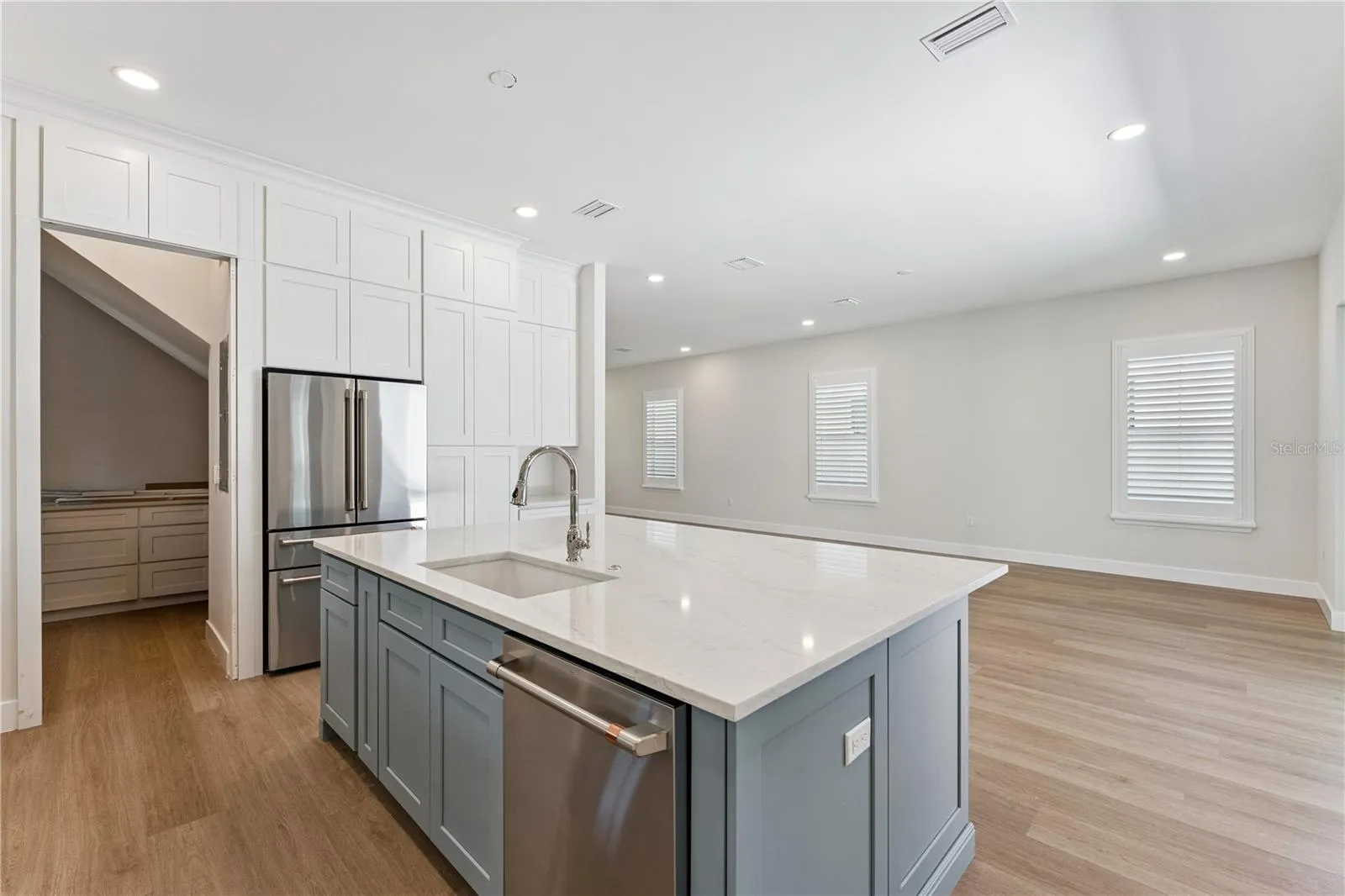 A closer view of the blue kitchen island highlights the sink, dishwasher, and surrounding cabinetry.