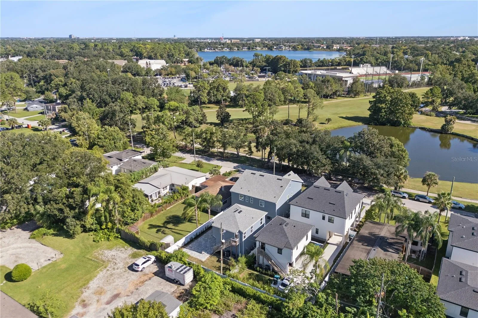 An aerial view shows the home and surrounding neighborhood, with the golf course and pond across the street.