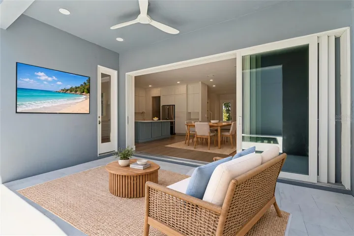 Virtually Staged - The covered rear patio has a ceiling fan and sliding doors to the main living area.