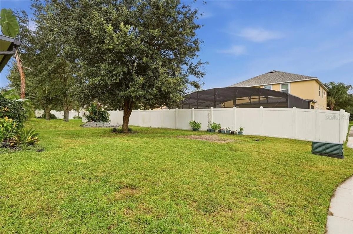 Large backyard with shaded with an oak tree