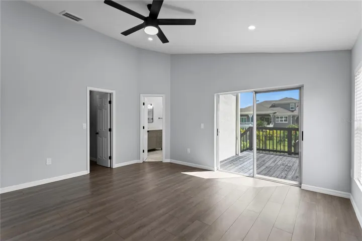 The primary bedroom features sliding doors that lead to the private deck.
