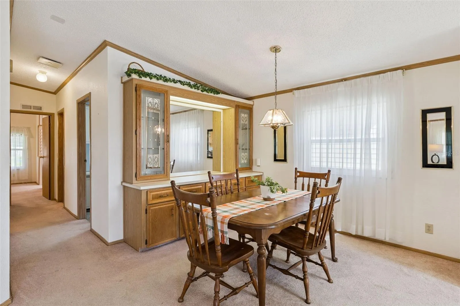 Dining room with built-in lighted china hutch and pendant light