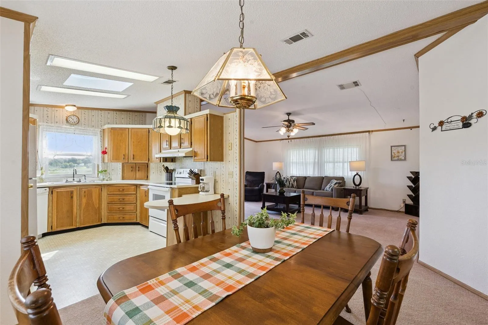 Dining room open to the kitchen with skylights and the living room beyond