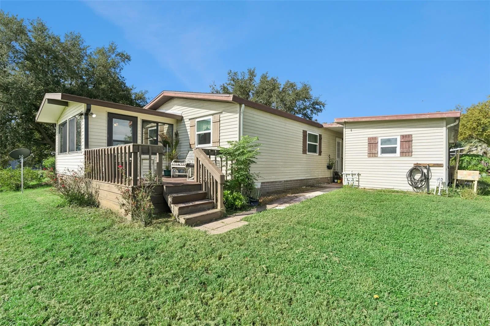 Rear exterior with deck, steps and backyard lawn