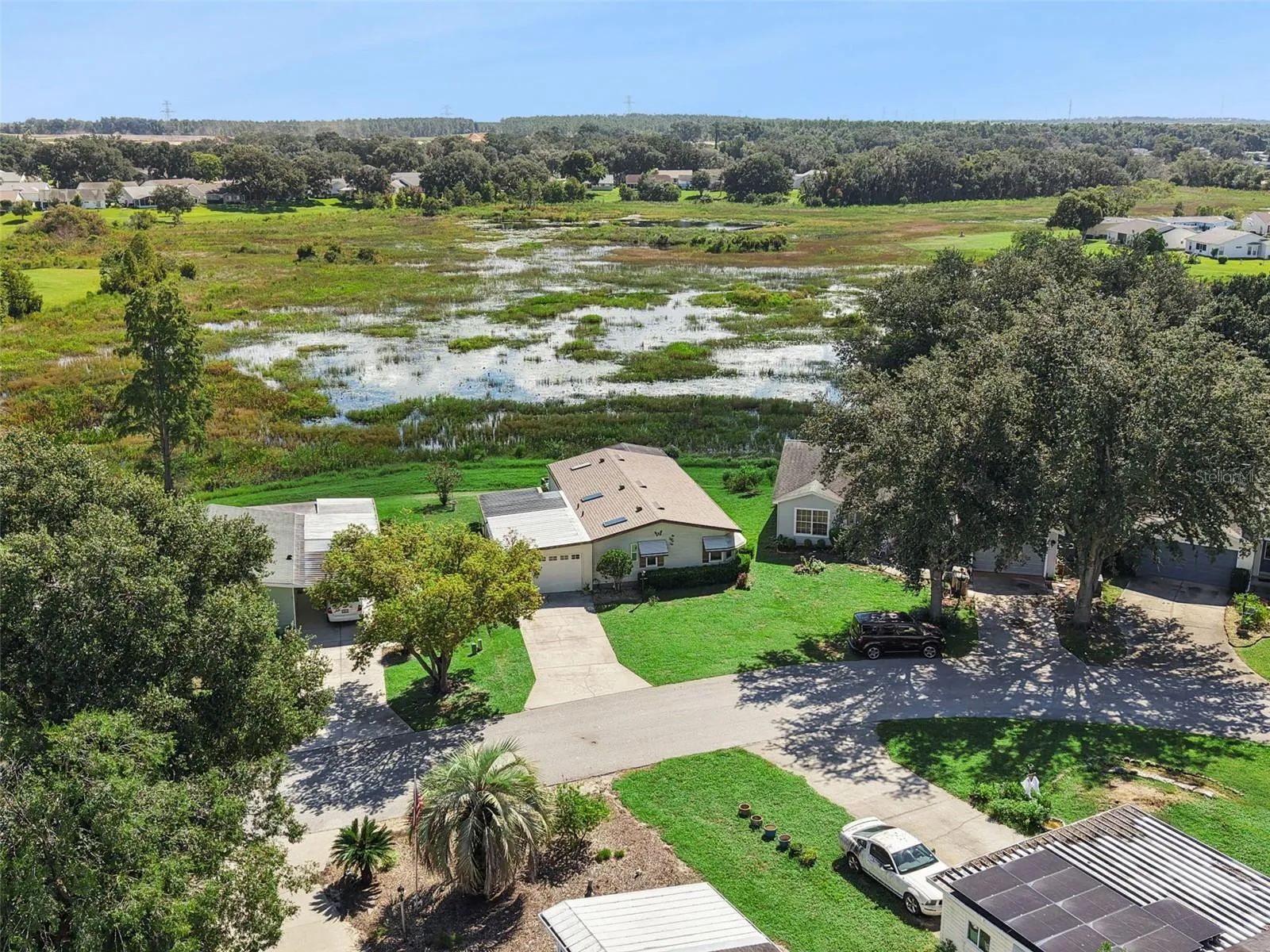 Aerial view of the home and street with the marsh behind