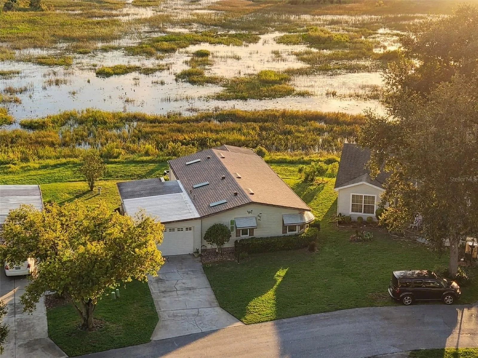 Digitally enhanced golden-hour light: close aerial view of the home with the marsh behind
