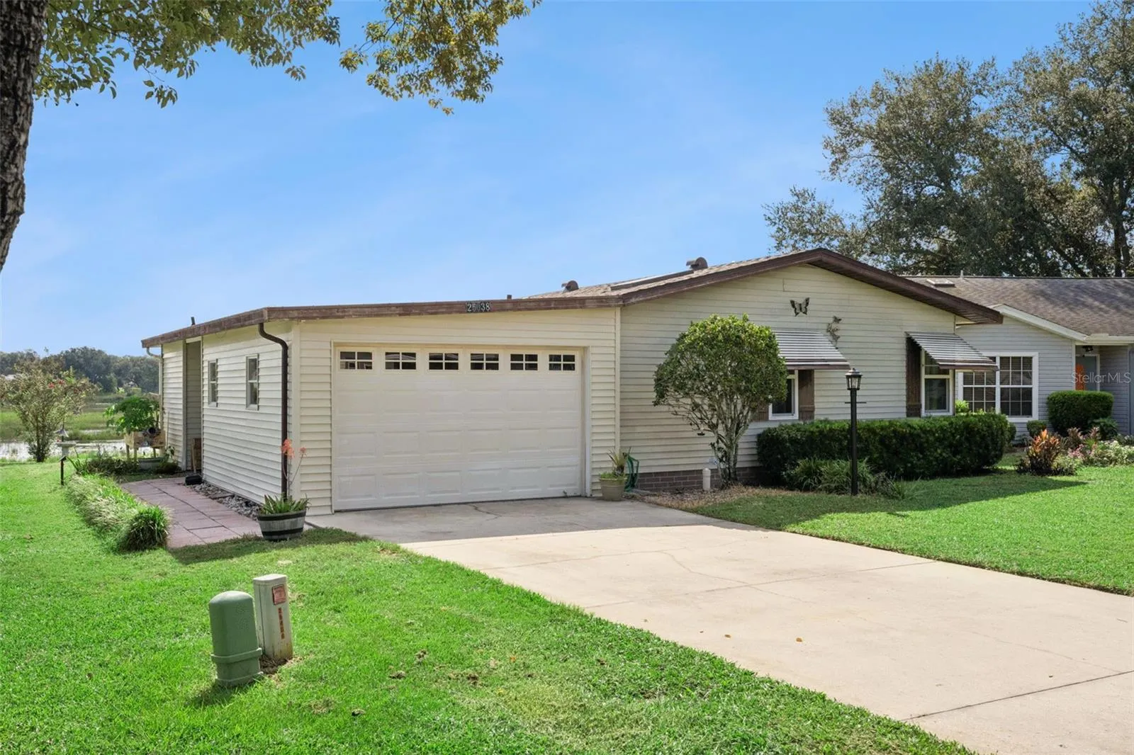 Front exterior from the driveway, showing the garage, side walkway and marsh beyond