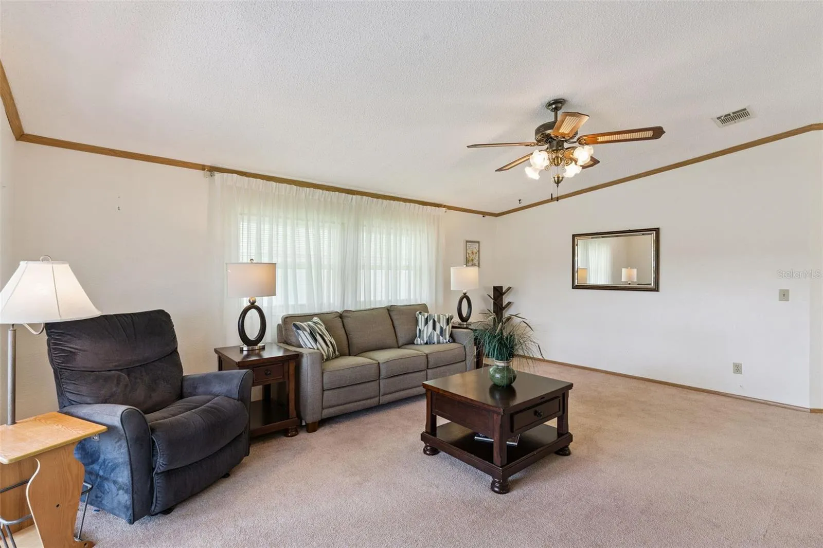 Living room with large front windows and a vaulted ceiling