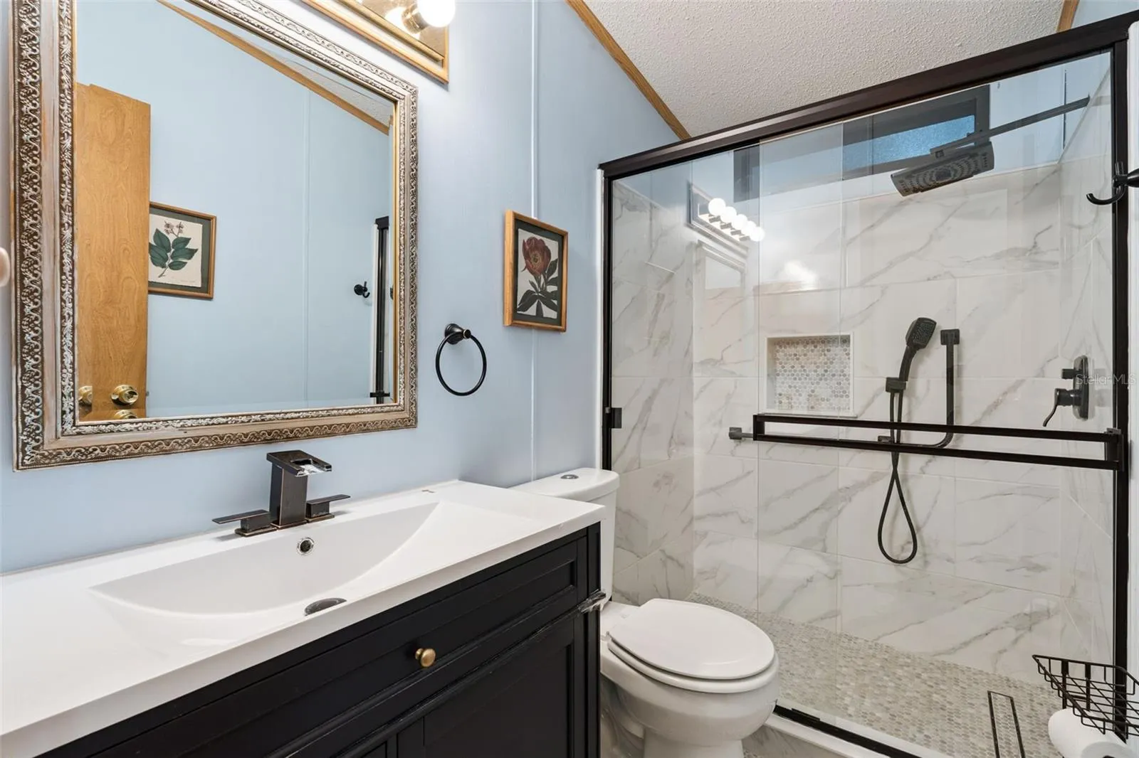 Updated guest bathroom with tiled walk-in shower, glass doors and new vanity