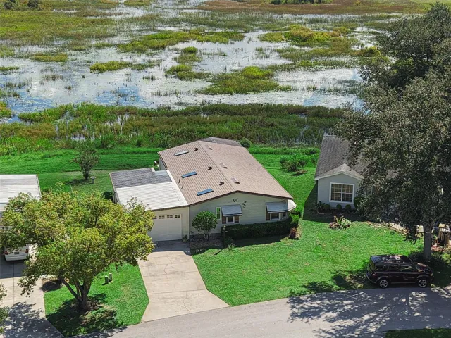 Close aerial view of the home, driveway and the marsh behind