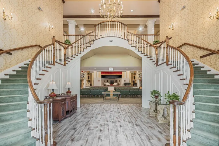 Community amenity: clubhouse foyer with double staircase and chandelier