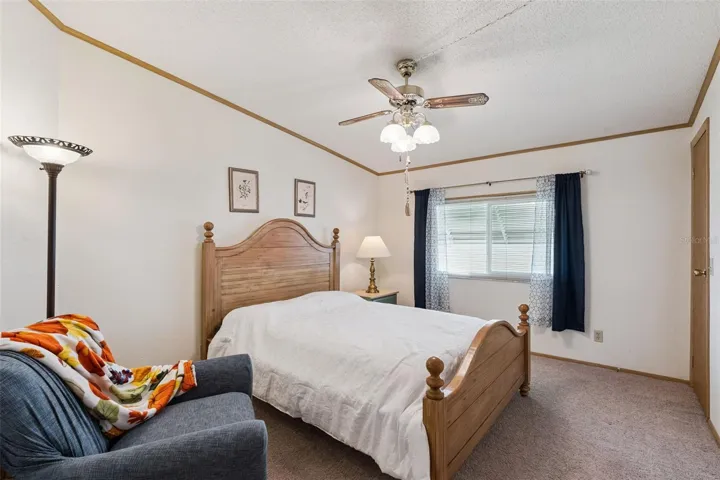 Guest bedroom with ceiling fan and window