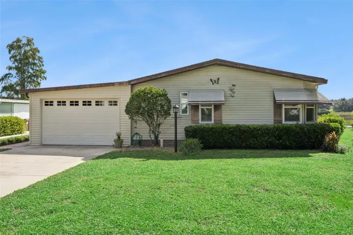 Front exterior with attached garage, wide driveway and landscaped front yard