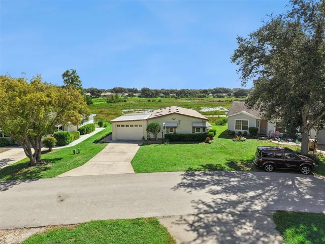 Elevated street view of the home and driveway with the marsh behind