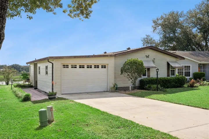 Front exterior from the driveway, showing the garage, side walkway and marsh beyond