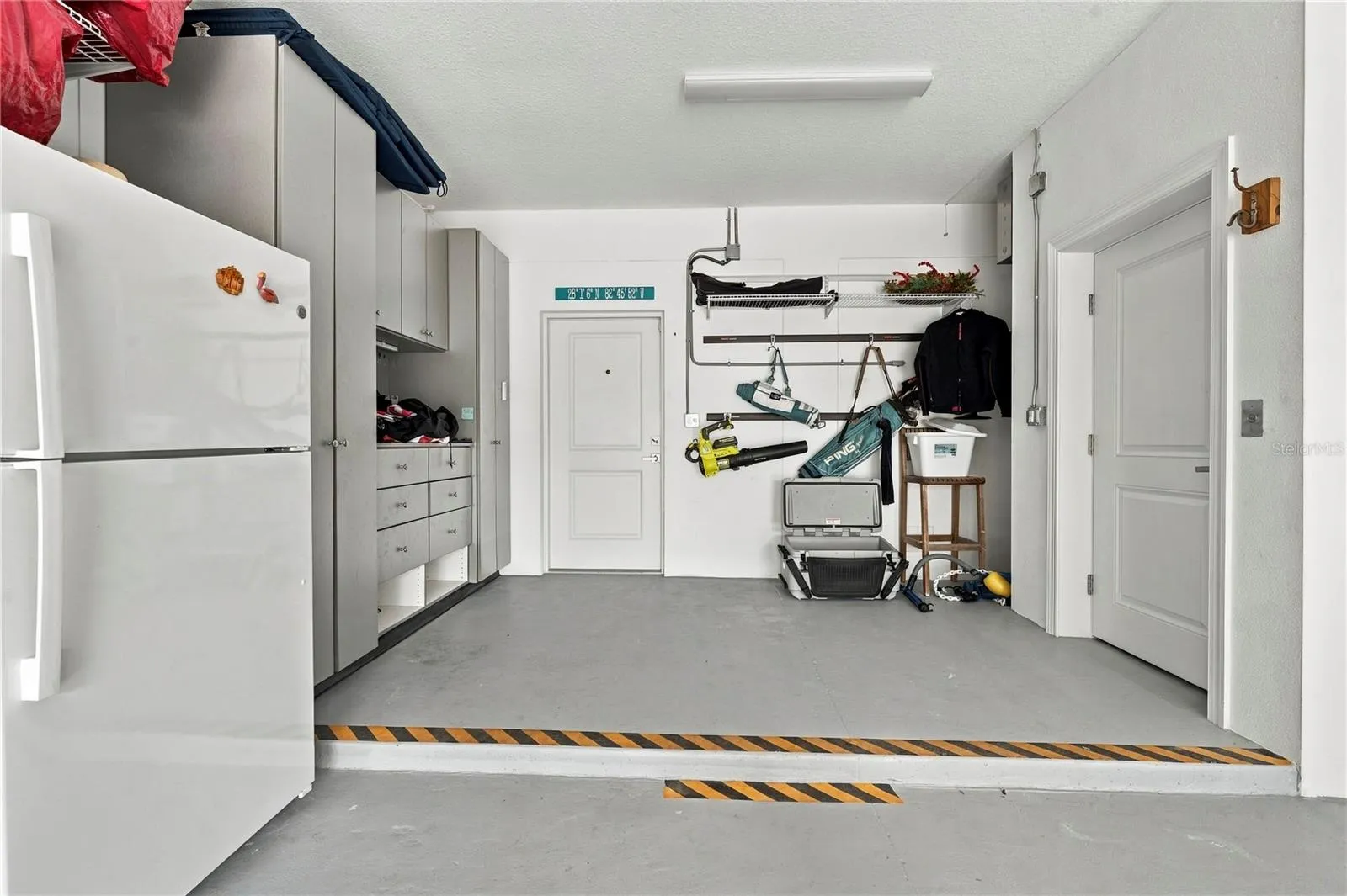 garage elevator to the right with extra storage to the left, outside access door straight ahead