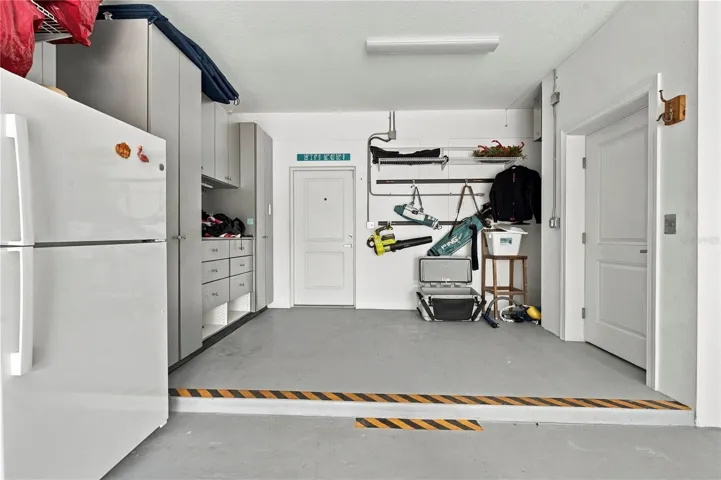 garage elevator to the right with extra storage to the left, outside access door straight ahead
