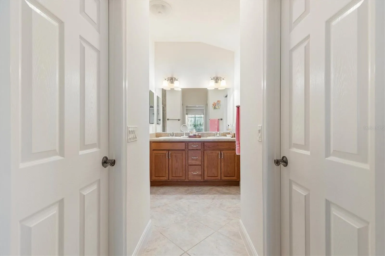 Primary ensuite with two walk-in closets, walk-in shower, dual sinks, and private water closet.