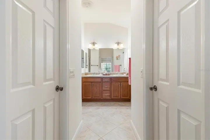 Primary ensuite with two walk-in closets, walk-in shower, dual sinks, and private water closet.