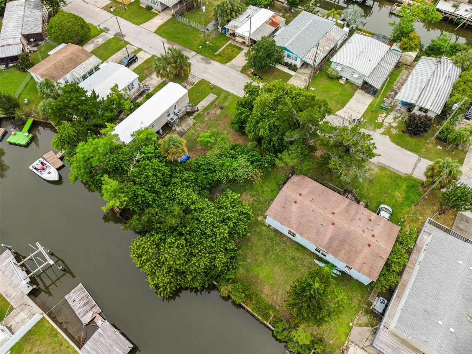 Aerial perspective showing the property’s peaceful waterfront location and neighboring homes.