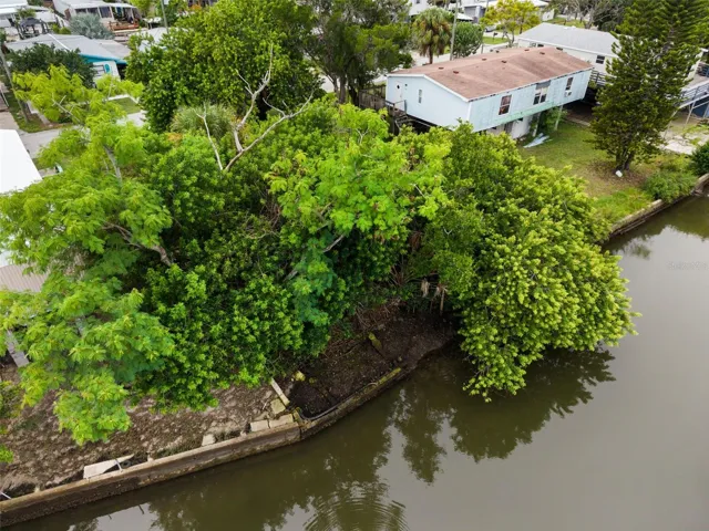 Closer aerial view of the canal frontage, seawall, and natural surroundings.