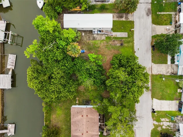 Top-down view of this wooded waterfront homesite with mature vegetation and canal frontage.