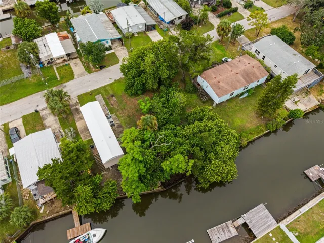 Aerial view of the property offering a natural waterfront setting with mature trees and privacy.