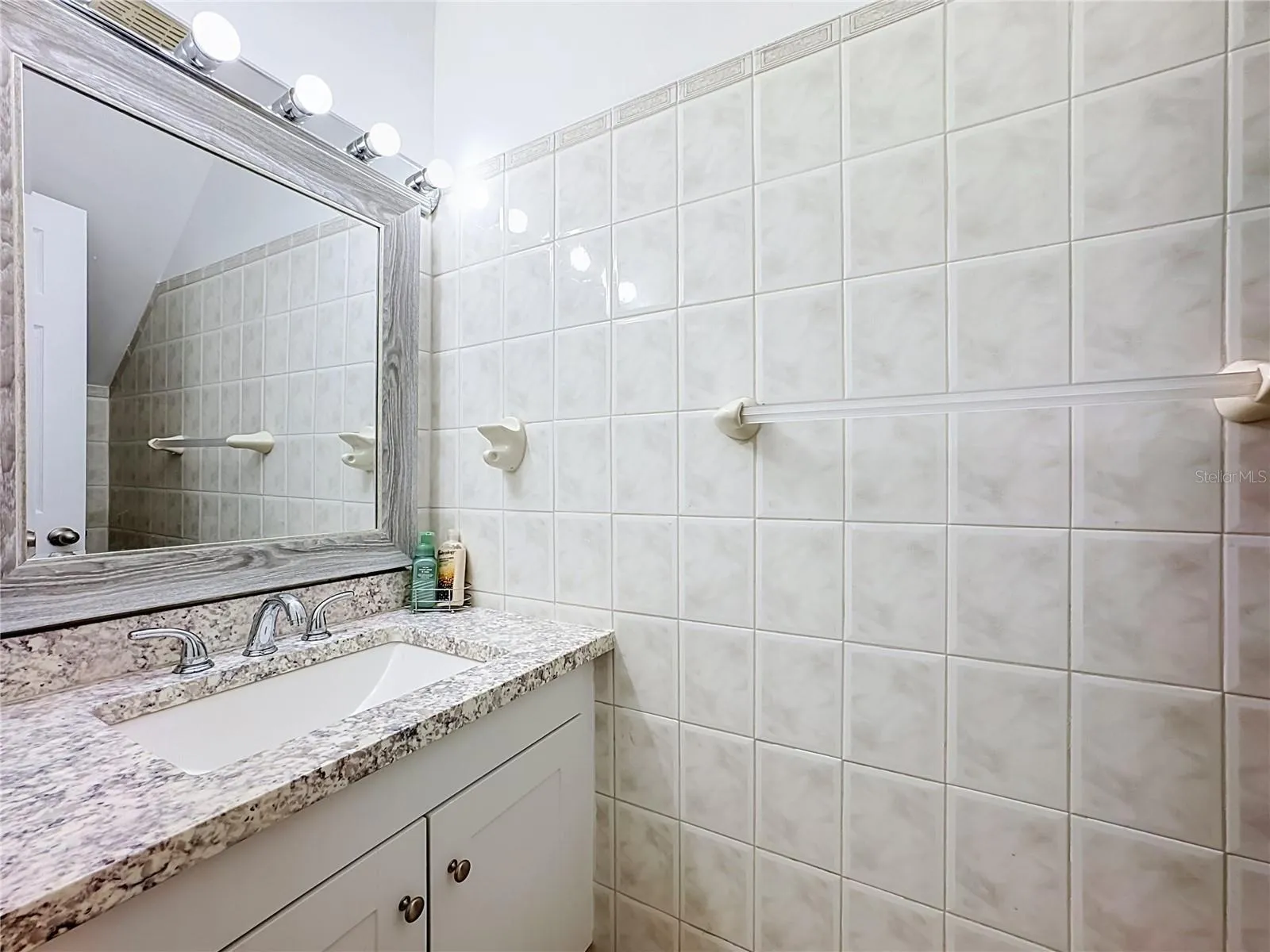 Bathroom vanity with tiled walls.