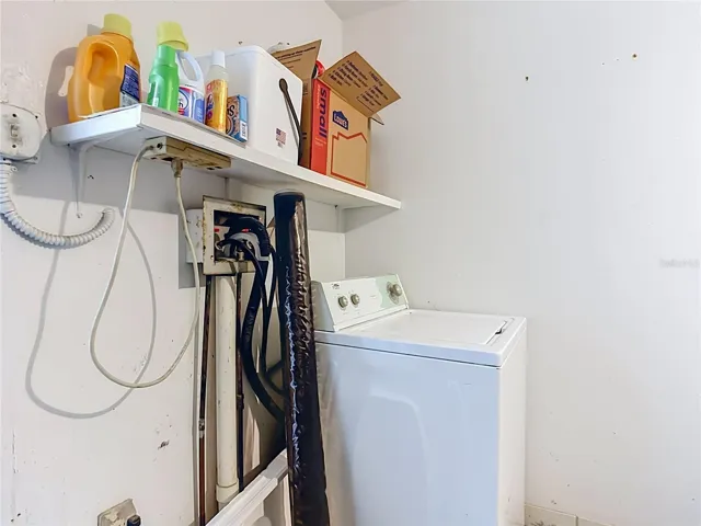 Laundry area with overhead storage.