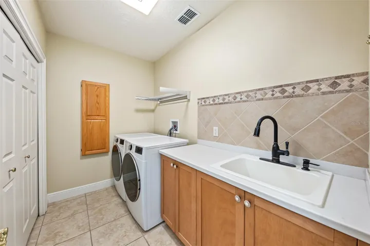 Large laundry room with full storage closet and sink