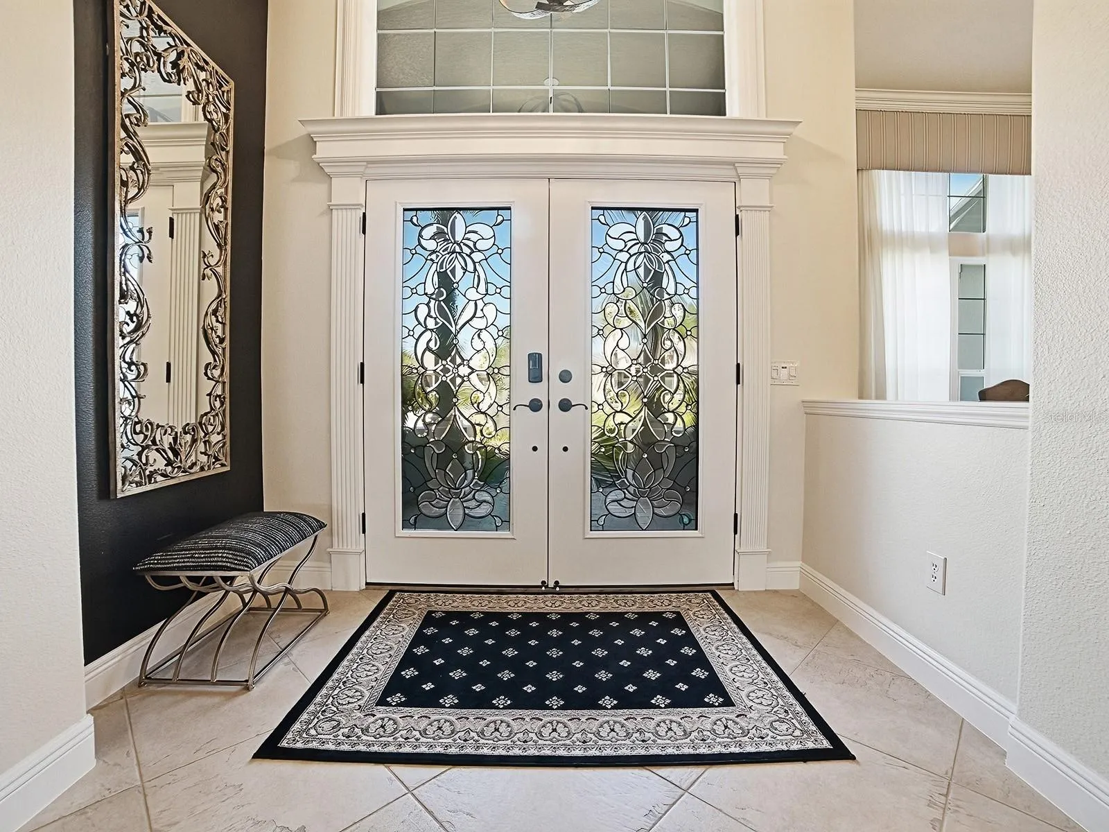 BEAUTIFUL FOYER WITH TRANSOM AND CUSTOM TRIM AND DIAGONAL TILE FLOORING.