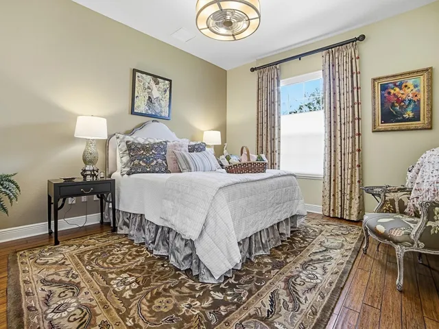 LOVELY GUEST ROOM ON THE OPPOSITE SIDE OF THE HOME WITH HARDWOOD FLOORING, CUSTOM DRAPES, AND NEW FANDELIER LIGHT FIXTURE.