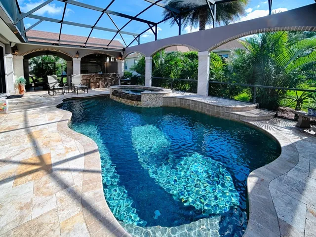 BEAUTIFUL TRAVERTINE DECKING AND TRAVERTINE COLUMNS WITH BRICK ACCENTS.