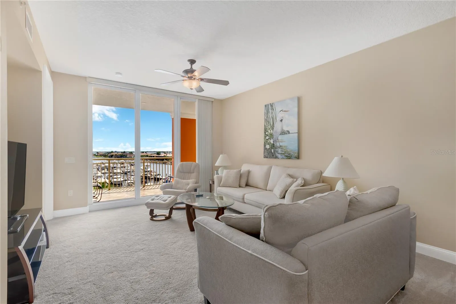Living Room features Sliding Glass Doors to Lanai overlooking the Riviera Dunes Marina