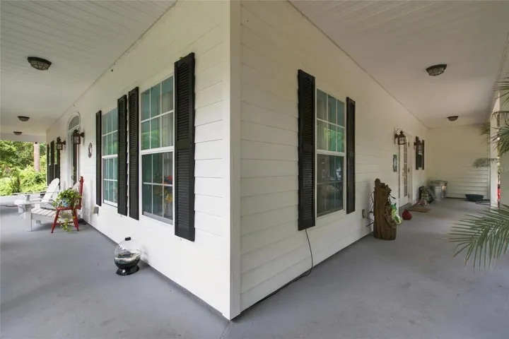 Front porch showing area that wraps around to the kitchen ending in the garage wall.