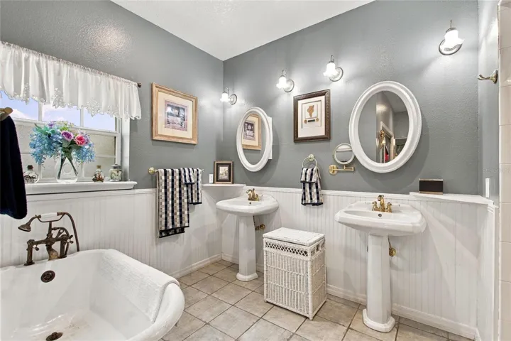 The primary bedroom has a clawfoot bath tub, two pedastal sinks, shower and water closet.