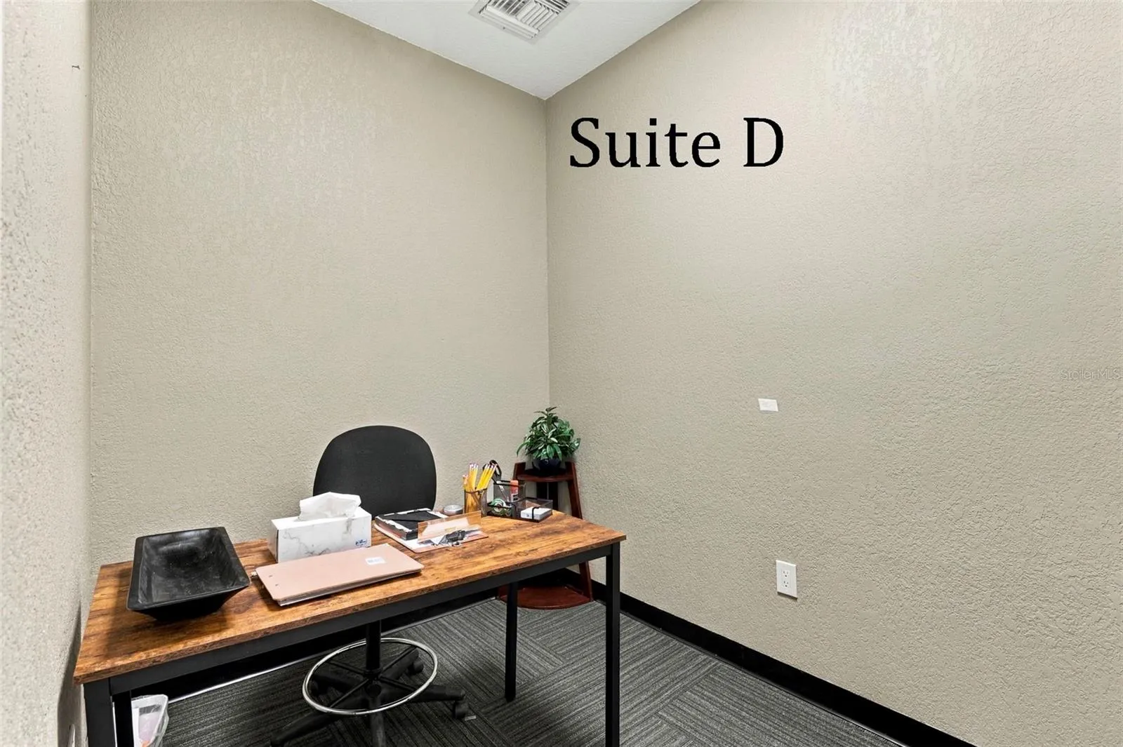 Suite D has a high window and is located near the hall restroom and Covered Patio Break Common Area