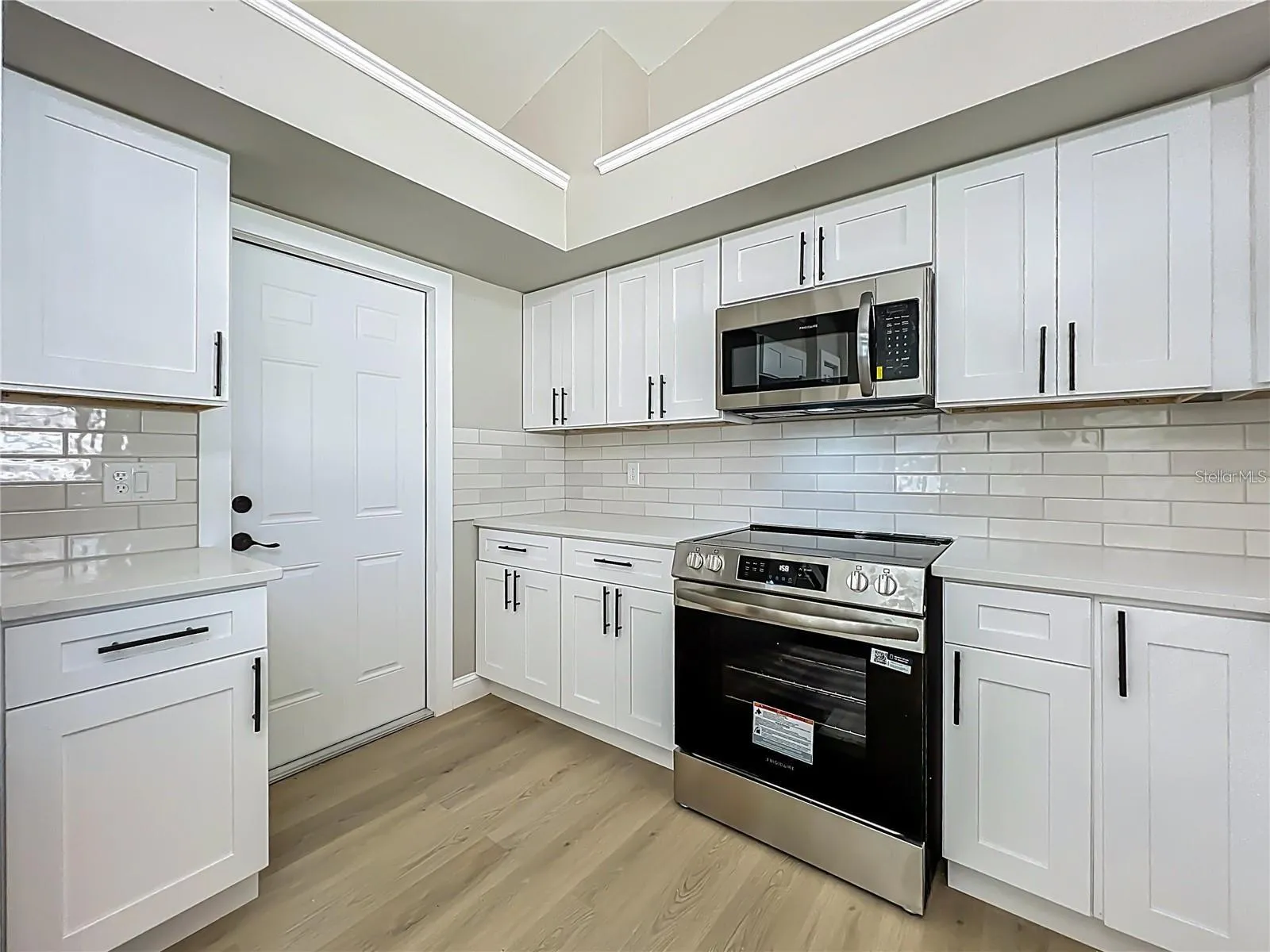 View of kitchen toward garage exit door way.