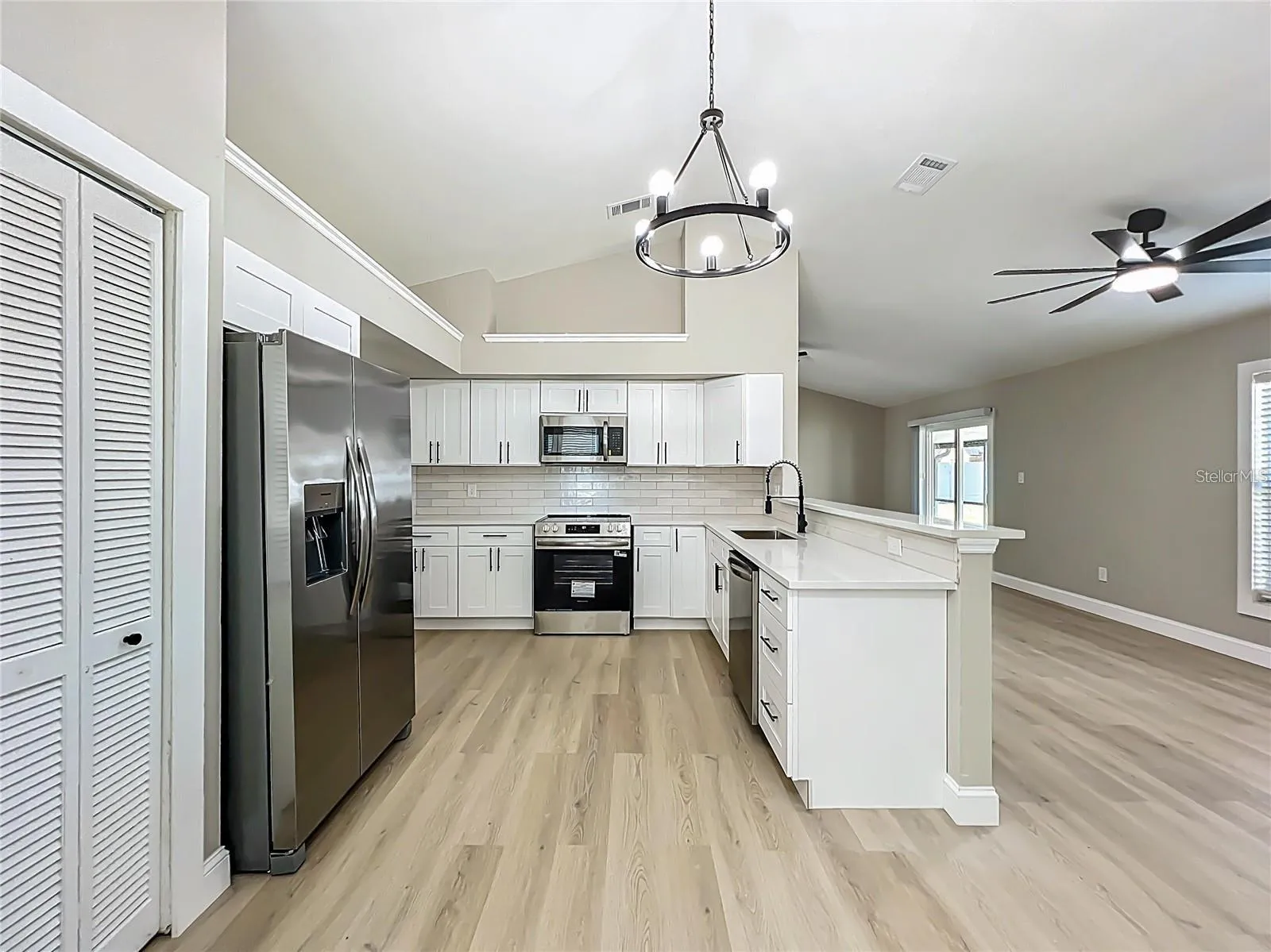 View of kitchen from dinette area toward living room.