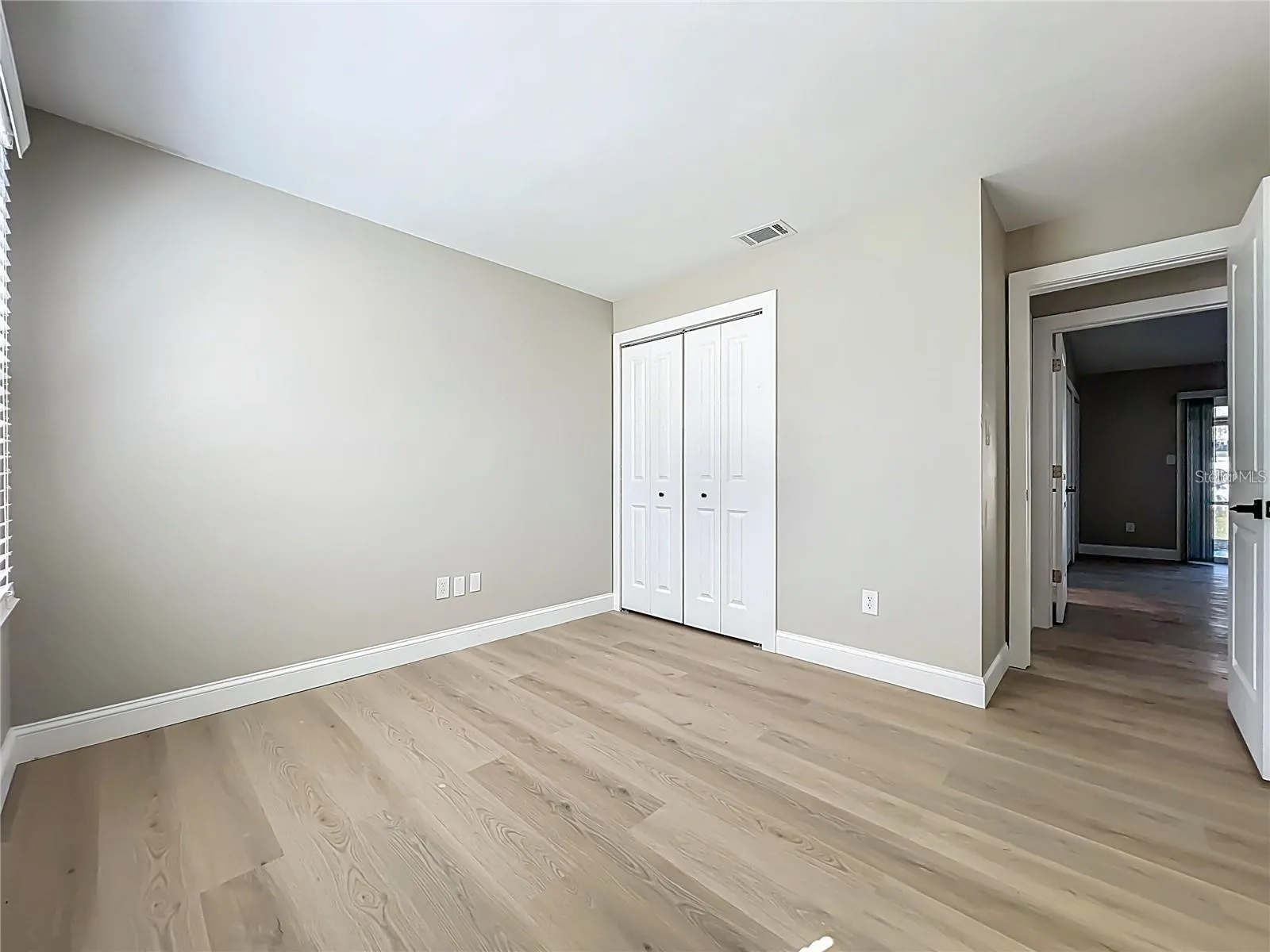 View of bedroom one, toward entrance and closet.