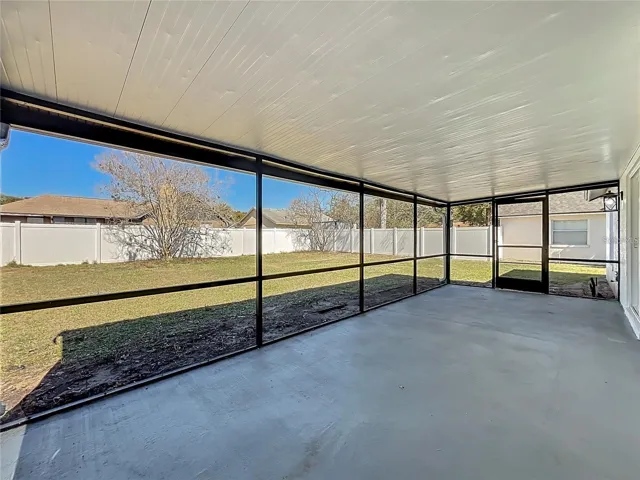 View of screened in patio and fenced backyard.