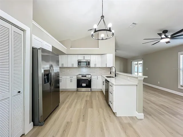 View of kitchen from dinette area toward living room.