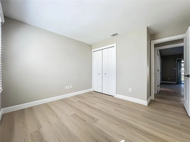 View of bedroom one, toward entrance and closet.