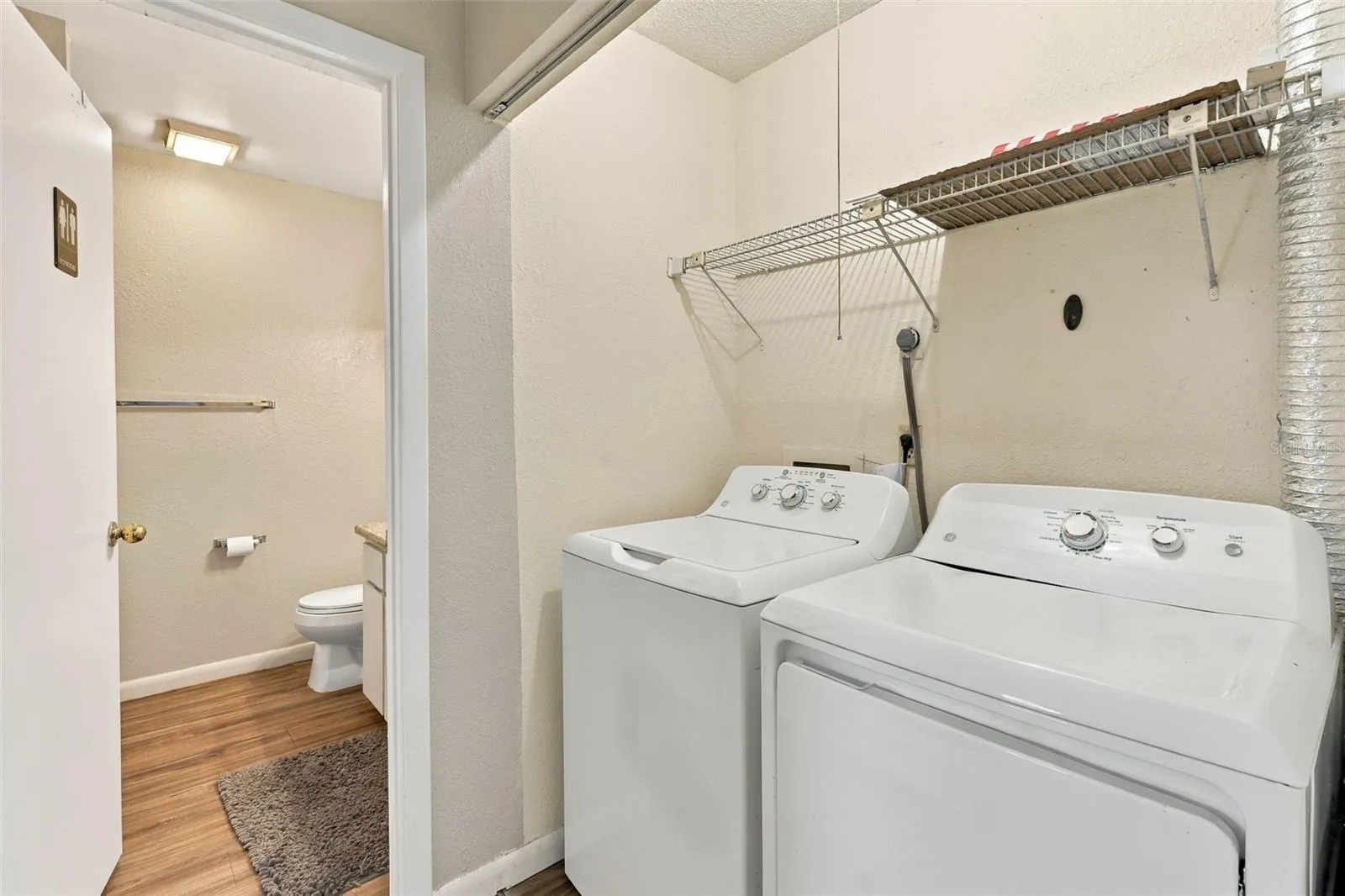 hallway to guest bath with washer and dryer included
