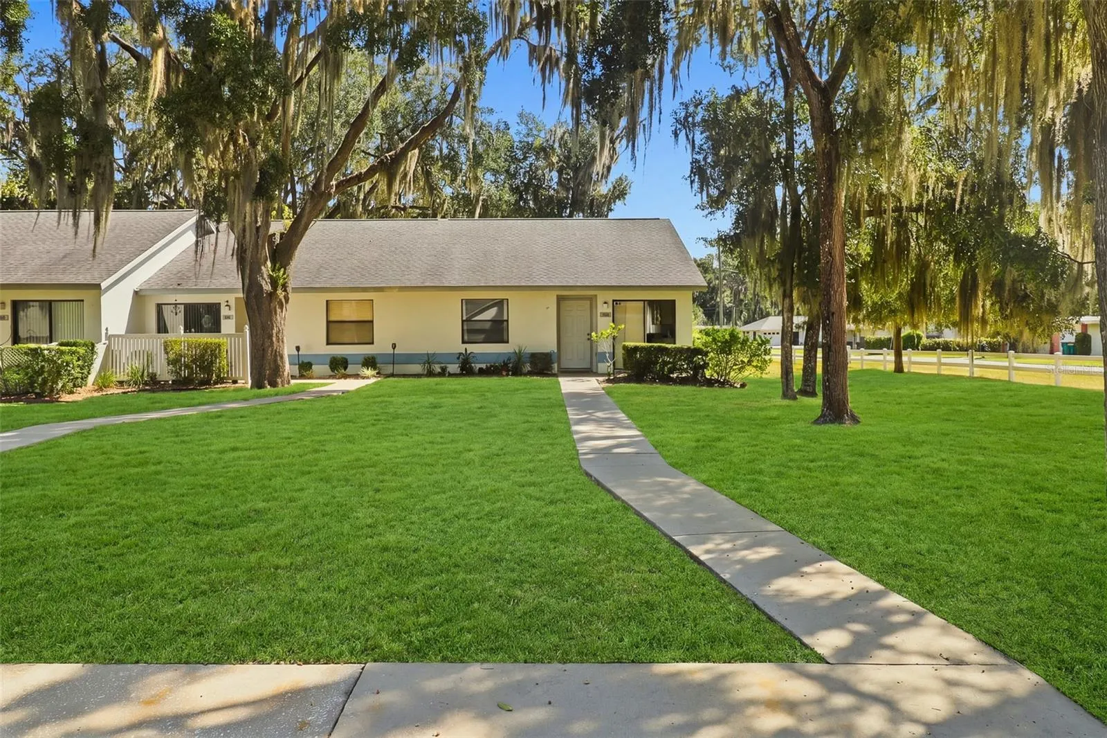 front view of townhouse and front yard with walk up sidewalk from parking spot