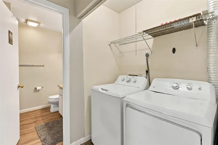 hallway to guest bath with washer and dryer included